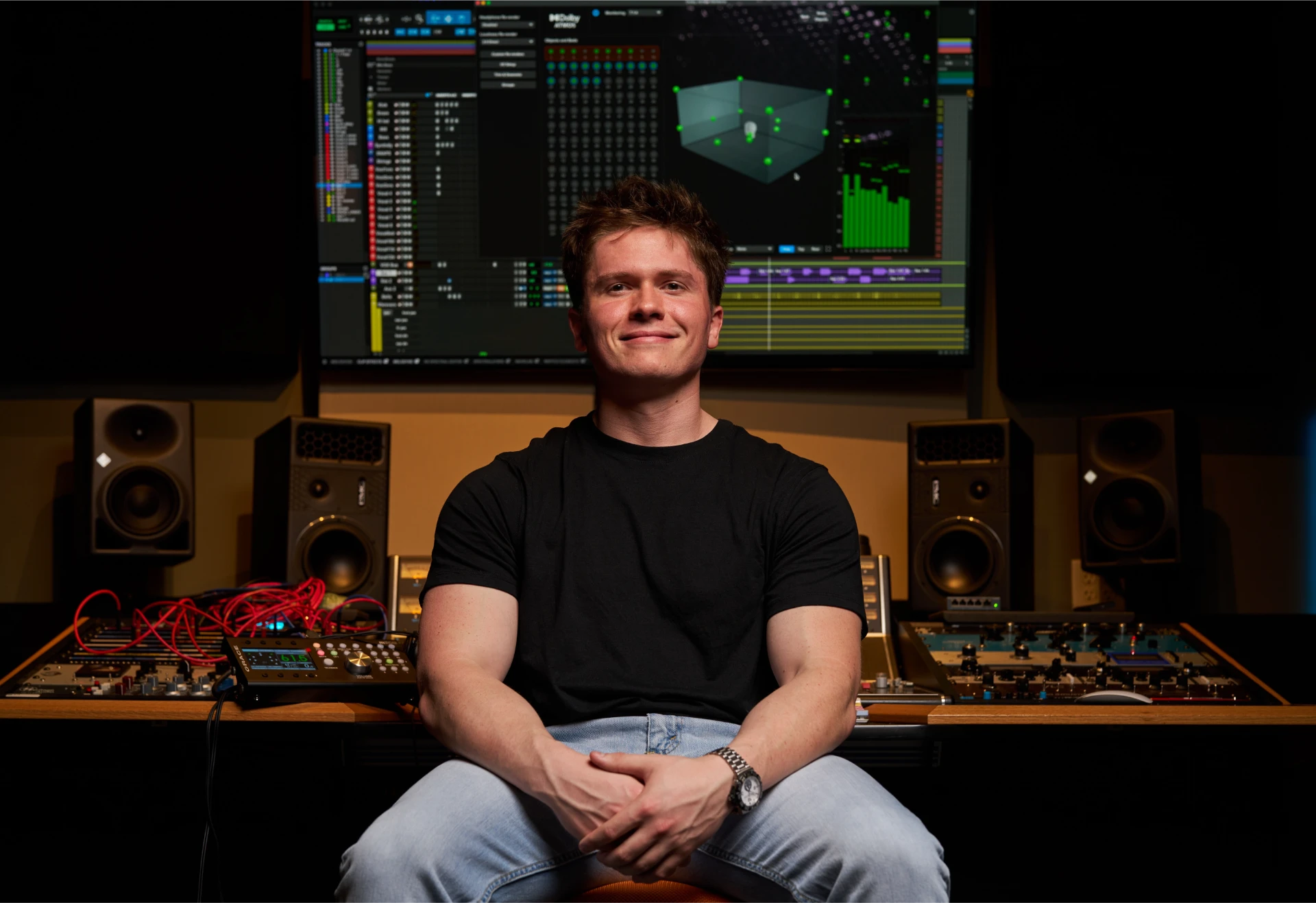 Jason Kushy surrounded by studio gear producing electronic music