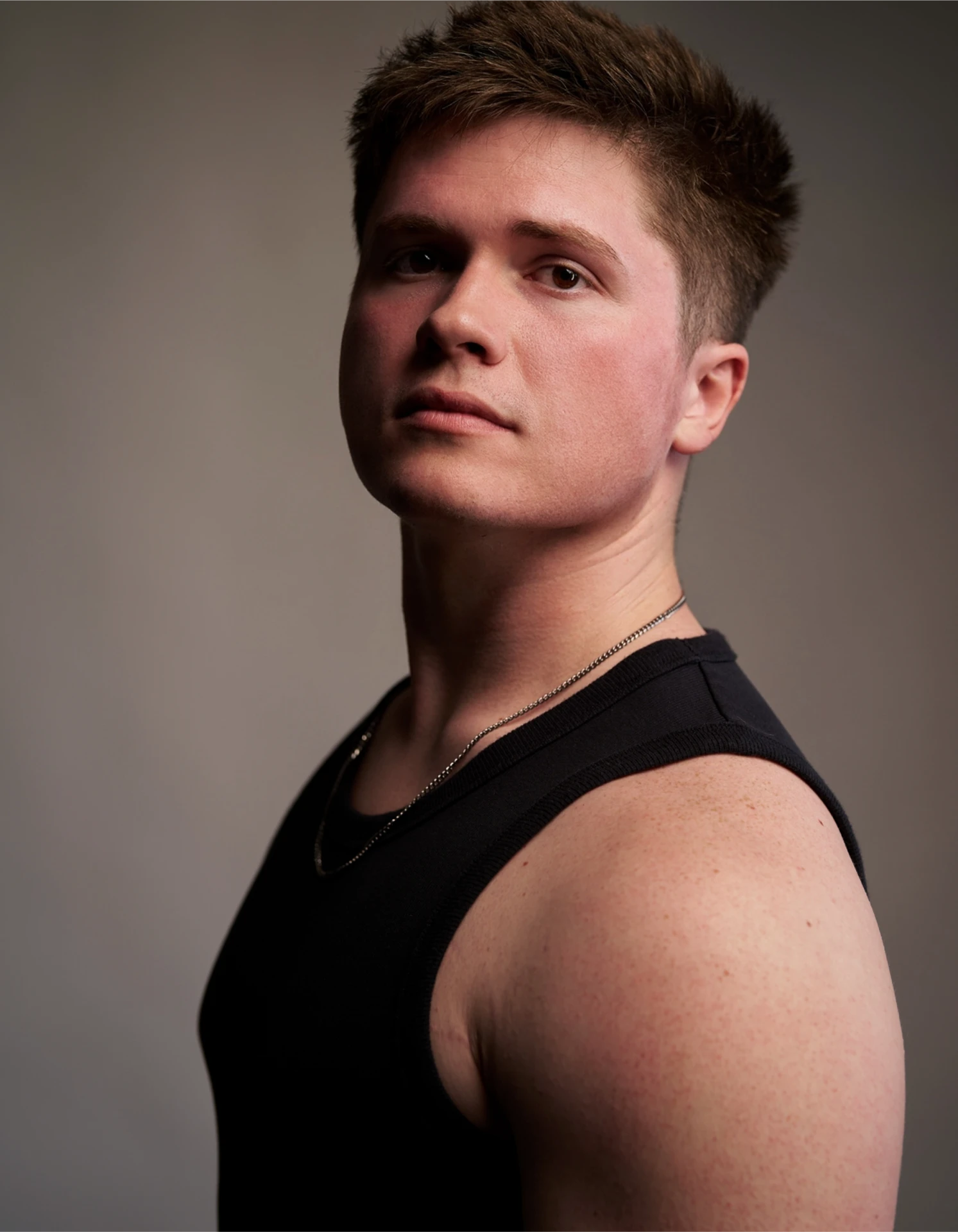 Studio portrait of Jason Kushy in a black tank top with dramatic side lighting